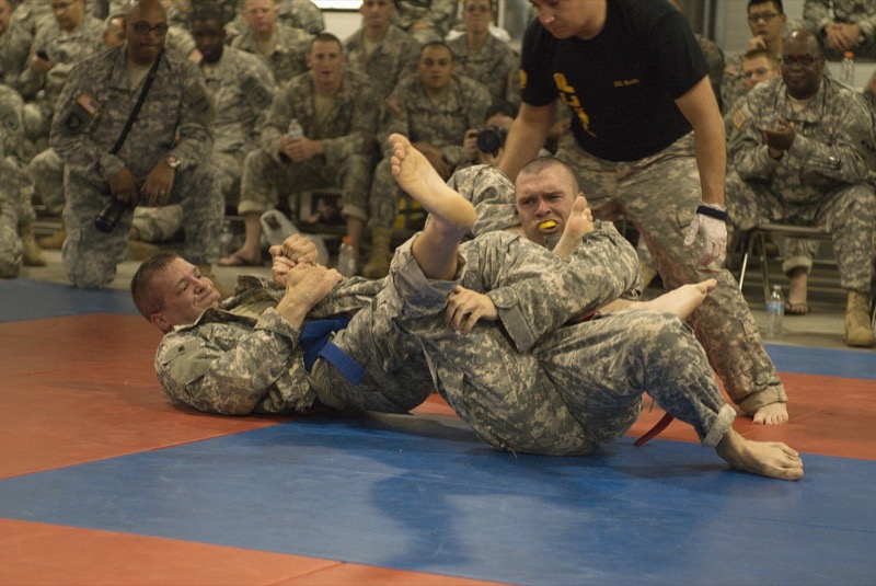 One competitor finishes an arm bar on another during a combatives tournament.