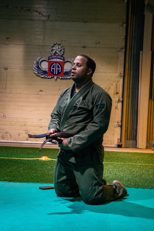 A grappler ties the belt of his gi before class.