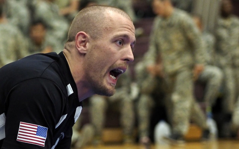 A jiu-jitsu coach shouts encouragement from the edge of the mat.