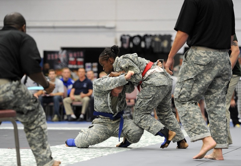 Two competitors grapple on the mat during a tournament semifinal.