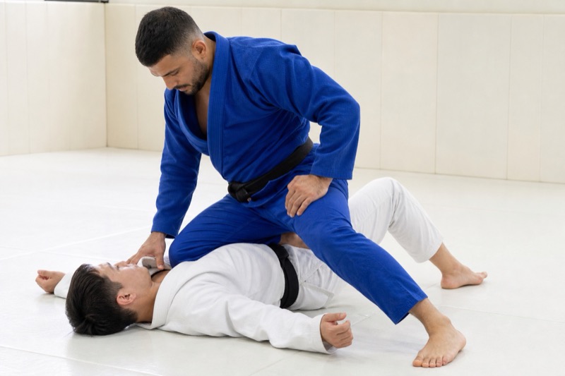 The top player plants a knee in the bottom player's torso with the other leg posted for base.